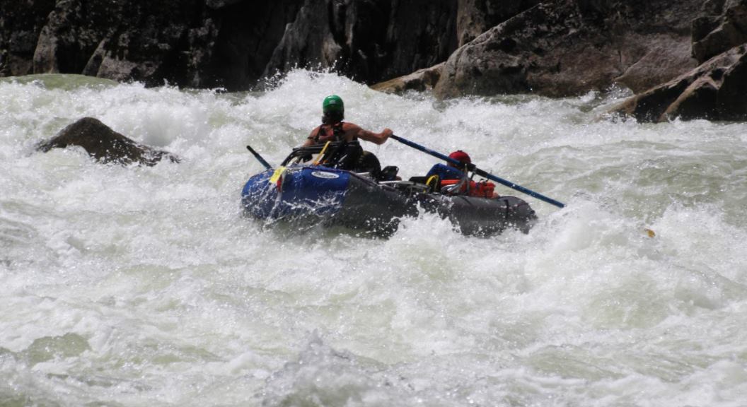Class V Nimbus raft frame on 13' raft with an oarsman, passenger, and gear for multi-day trip in extreme whitewater